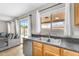 View of kitchen sink with stainless steel dishwasher, bright window, and access to the backyard at 1754 E Bradstock Way, San Tan Valley, AZ 85140