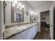 This bathroom features granite counters, double sinks, and access to another room at 17806 N 54Th Ln, Glendale, AZ 85308