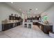 Full view of the spacious open kitchen with dark cabinets and tiled flooring at 17806 N 54Th Ln, Glendale, AZ 85308