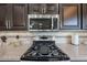 Close up of gas range, microwave, and granite counters in updated kitchen at 17806 N 54Th Ln, Glendale, AZ 85308