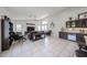 Open concept living room featuring a wet bar, entertainment center, and tiled floors at 17806 N 54Th Ln, Glendale, AZ 85308