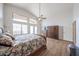 Bright main bedroom with wood-look tile, vaulted ceilings, fan, and backyard access at 17806 N 54Th Ln, Glendale, AZ 85308