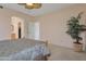 Spacious bedroom featuring carpet, a decorative plant, and access to the en-suite bathroom and closet at 17939 N Encanto Dr, Surprise, AZ 85374