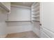 Walk-in closet featuring bright white walls, shelving, and metal rods for organized storage at 17939 N Encanto Dr, Surprise, AZ 85374