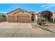 A three-car garage and desert-friendly landscaping complements the home's curb appeal at 17939 N Encanto Dr, Surprise, AZ 85374