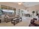 Bright living room featuring a sofa, coffee table, and view of the dining area through large windows at 17939 N Encanto Dr, Surprise, AZ 85374