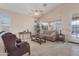 Bright living room featuring neutral sofa, side tables, and a ceiling fan at 17939 N Encanto Dr, Surprise, AZ 85374