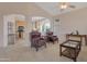 Inviting living room with leather chairs and view to the kitchen and bright rooms at 17939 N Encanto Dr, Surprise, AZ 85374