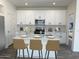 Stylish kitchen showcasing white cabinetry, stainless steel appliances, and seating at the center island at 17983 W Sand Hills Rd, Surprise, AZ 85387