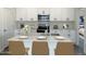 Well-appointed kitchen featuring white cabinets, a stainless steel microwave, and an island with bar stools at 17983 W Sand Hills Rd, Surprise, AZ 85387