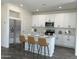 Beautiful kitchen with white cabinets, stainless steel appliances, and an island with barstool seating at 17983 W Sand Hills Rd, Surprise, AZ 85387