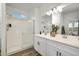 Modern bathroom with a double vanity, sleek countertops, a large mirror, and a glass-enclosed shower, offering a spa-like feel at 17995 W Sand Hills Rd, Surprise, AZ 85387