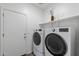 Well-equipped laundry room with modern washer and dryer, storage shelf, and access to the exterior at 238 W Kona Dr, Casa Grande, AZ 85122