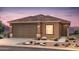 Beautiful single-story home featuring a brown exterior, attached garage and desert landscaping at 25176 W Wier Ave, Buckeye, AZ 85326