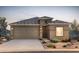 Inviting single-Gathering home showcasing a two-car garage, desert landscaping, and stone veneer accents at 25186 W Wier Ave, Buckeye, AZ 85326