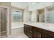 Bathroom featuring double sinks, a soaking tub, and a neutral color palette at 287 N Jesse St, Chandler, AZ 85225