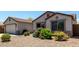 A single-story home exhibits a well-maintained yard with desert landscaping and a light neutral color palette at 30 S 230Th Ave, Buckeye, AZ 85326