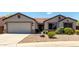 Charming single-story home featuring a low-maintenance desert landscape and attached two-car garage at 30 S 230Th Ave, Buckeye, AZ 85326