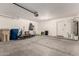 Spacious and well-lit two-car garage with ample storage and door to the interior at 30 S 230Th Ave, Buckeye, AZ 85326