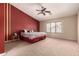 A primary bedroom featuring a ceiling fan, neutral carpeting, and a large window at 30 S 230Th Ave, Buckeye, AZ 85326