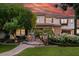 Two-story home with stone accents, mature trees, manicured lawn and garden, and a stone pathway to the entrance at 3011 E Morrison Ranch Pkwy, Gilbert, AZ 85296