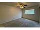Bright bedroom featuring neutral carpet, a ceiling fan, and a large window at 3150 E Corrine Dr, Phoenix, AZ 85032
