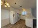 Bright kitchen features white cabinetry and appliances, plus wood flooring and island bar at 3150 E Corrine Dr, Phoenix, AZ 85032