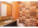 Chic half-bath featuring patterned wallpaper, a granite-topped vanity, and a toilet at 35756 N Clementine Trl, San Tan Valley, AZ 85140