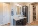 Bright bathroom featuring a granite-topped vanity, framed mirror, and a convenient walk-in closet at 35756 N Clementine Trl, San Tan Valley, AZ 85140