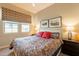 Cozy bedroom with patterned bedding, matching curtains, and framed artwork creating a peaceful retreat at 35756 N Clementine Trl, San Tan Valley, AZ 85140