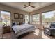Bright bedroom featuring a ceiling fan, three large windows, and comfortable furnishings at 35756 N Clementine Trl, San Tan Valley, AZ 85140