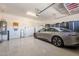 Clean garage featuring epoxy floors, storage cabinets, and a modern electric vehicle at 35756 N Clementine Trl, San Tan Valley, AZ 85140