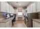 Well-organized laundry room featuring stainless steel appliances, ample cabinet space, and a built-in desk at 35756 N Clementine Trl, San Tan Valley, AZ 85140