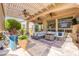 Comfortable covered patio area with plush seating, ceiling fans, and a stylish fire pit on a decorative rug at 35756 N Clementine Trl, San Tan Valley, AZ 85140