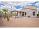 This backyard features a covered patio and desert landscaping for low maintenance living at 4205 W Maggie Dr, San Tan Valley, AZ 85144