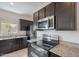 Stylish kitchen boasts stainless steel appliances, granite countertops, and dark wood cabinetry for a modern aesthetic at 4205 W Maggie Dr, San Tan Valley, AZ 85144