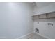 Bright laundry room with tile flooring, shelving, and washer/dryer hookups at 4205 W Maggie Dr, San Tan Valley, AZ 85144