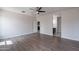 Spacious main bedroom with wood-look floors, ceiling fan, and doorway views into the en-suite and kitchen at 4205 W Maggie Dr, San Tan Valley, AZ 85144