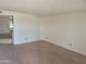 Open living room with neutral paint, neutral carpet, and kitchen access at 5139 E Tano St, Phoenix, AZ 85044