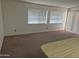 Bright and airy living room with large windows and neutral carpeting at 5139 E Tano St, Phoenix, AZ 85044