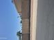 View of the sidewalk, street, brick wall, and wooden fence with palm trees in the distance at 5139 E Tano St, Phoenix, AZ 85044