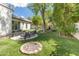 Landscaped backyard with artificial turf, seating, fire pit, mature trees, and outdoor grill at 523 W Vista Ave, Phoenix, AZ 85021
