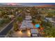 Expansive aerial view showcasing a Scottsdale home with a sparkling pool, lush landscaping, and mountain views at sunset at 5837 E Presidio Rd, Scottsdale, AZ 85254