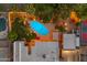 Aerial view of a backyard with a sparkling pool, lounge area and outdoor lighting, perfect for entertaining at 5837 E Presidio Rd, Scottsdale, AZ 85254