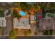 Aerial view of a landscaped property with a pool, tennis court, and illuminated backyard at 5837 E Presidio Rd, Scottsdale, AZ 85254