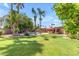 Spacious backyard with lush green lawn, trees, pool, and covered patio perfect for outdoor living at 5837 E Presidio Rd, Scottsdale, AZ 85254