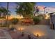 A tranquil backyard patio illuminated at dusk, offering comfortable seating and a peaceful retreat for relaxation and outdoor enjoyment at 5837 E Presidio Rd, Scottsdale, AZ 85254
