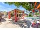 Backyard patio features poolside seating with red curtains, a pergola and lush landscaping at 5837 E Presidio Rd, Scottsdale, AZ 85254