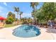 Lush backyard featuring a sparkling pool surrounded by palm trees, and outdoor dining area creating a private oasis at 5837 E Presidio Rd, Scottsdale, AZ 85254