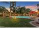 A sprawling backyard featuring a pool, a grass lawn, mature trees, and ample space for outdoor activities and relaxation at 5837 E Presidio Rd, Scottsdale, AZ 85254